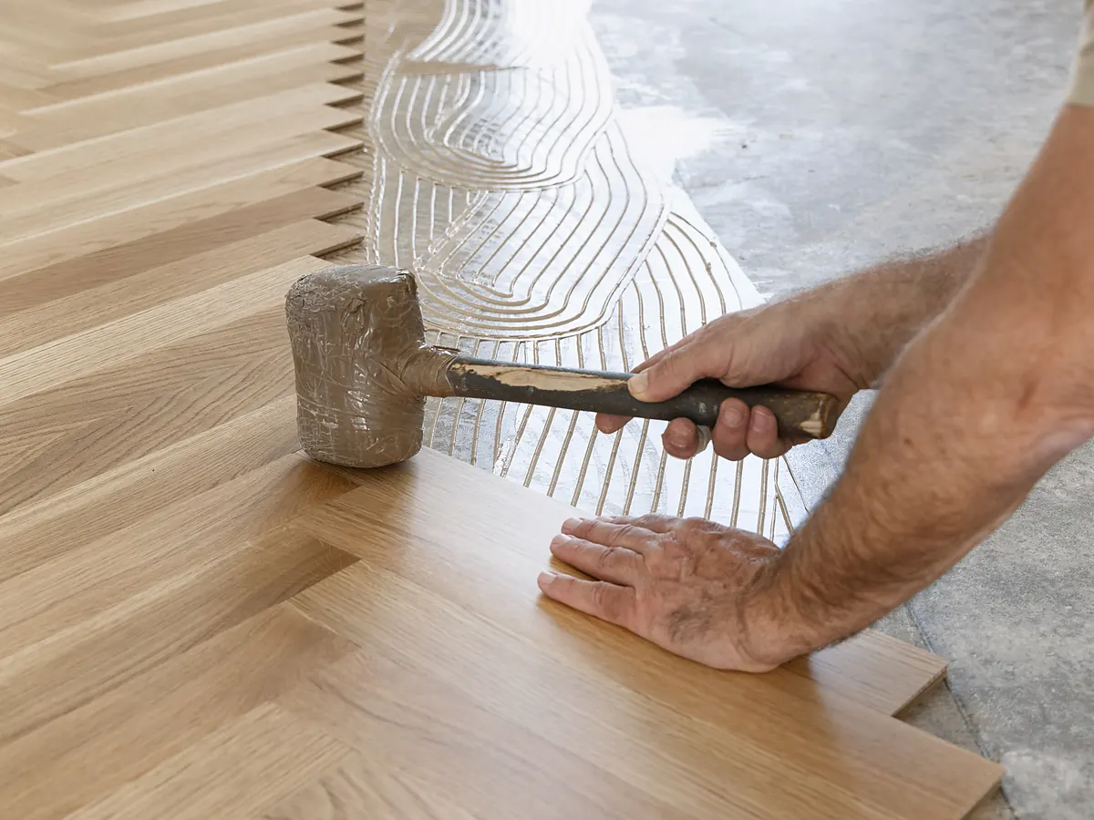 Engineered hardwood set into adhesive on a tested concrete slab for a below-grade Sioux Falls, SD room