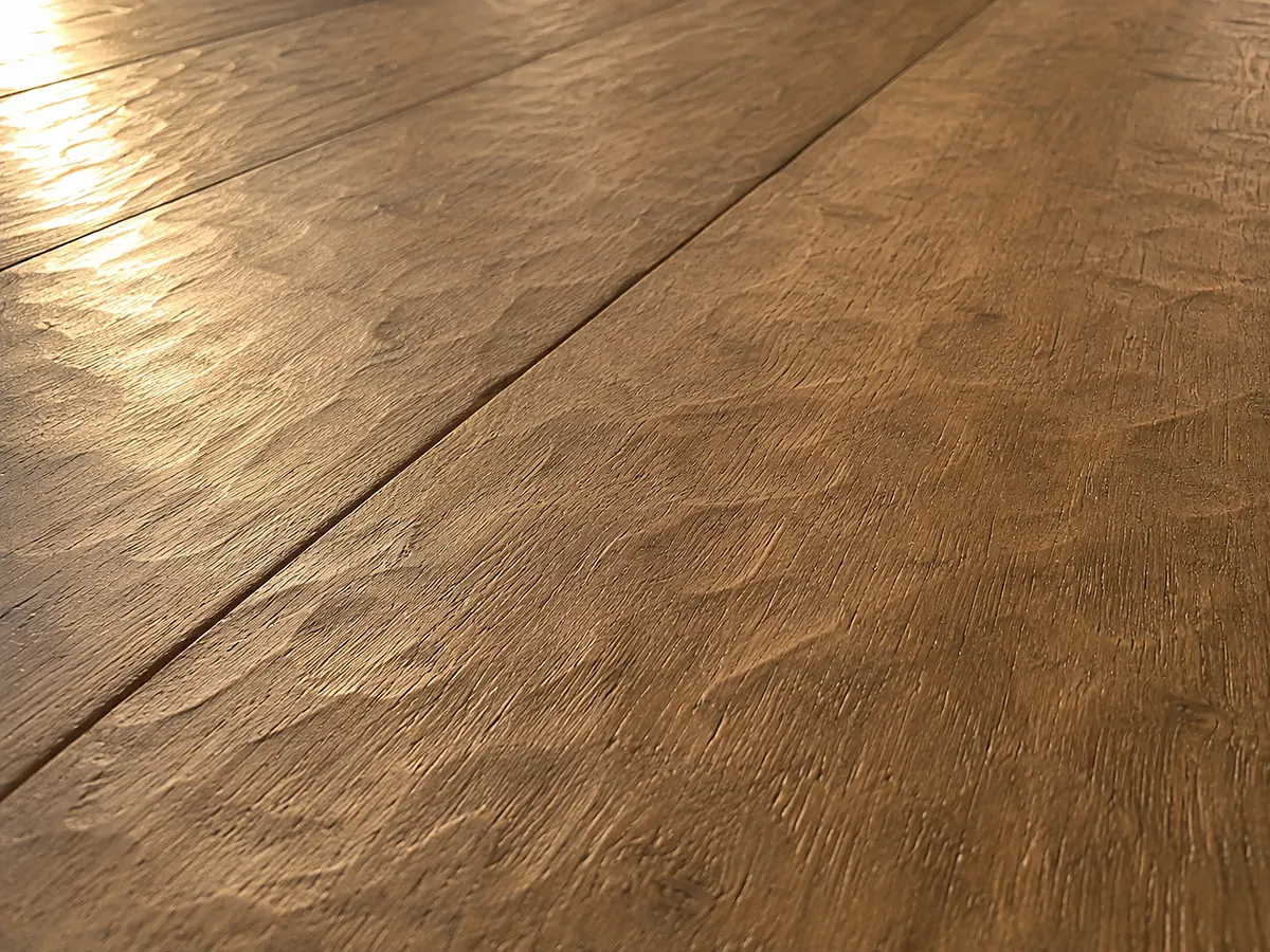 Hand-scraped oak floor with irregular shallow undulations across the board face