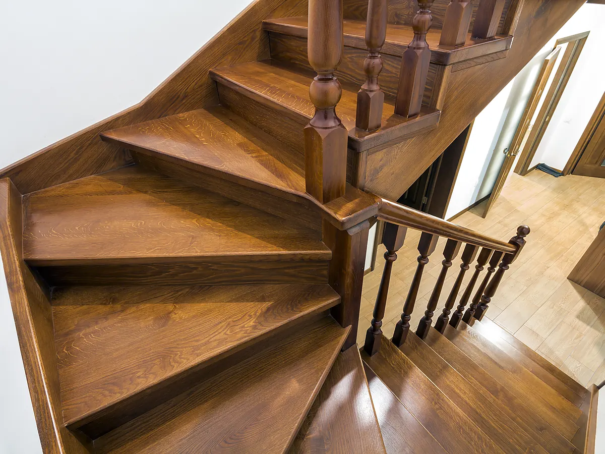 Refinished oak stair treads and risers meeting the hardwood floor at the landing in a Sioux Falls, SD home