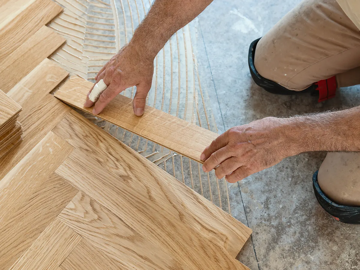 Installer laying an oak herringbone hardwood floor pattern in a Sioux Falls, SD home